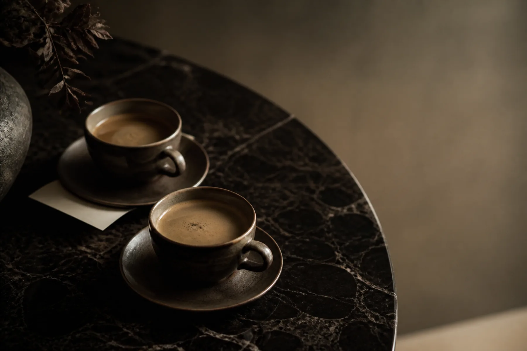 A poured water glass and a folded napkin on an empty table, the chair pushed neatly in.