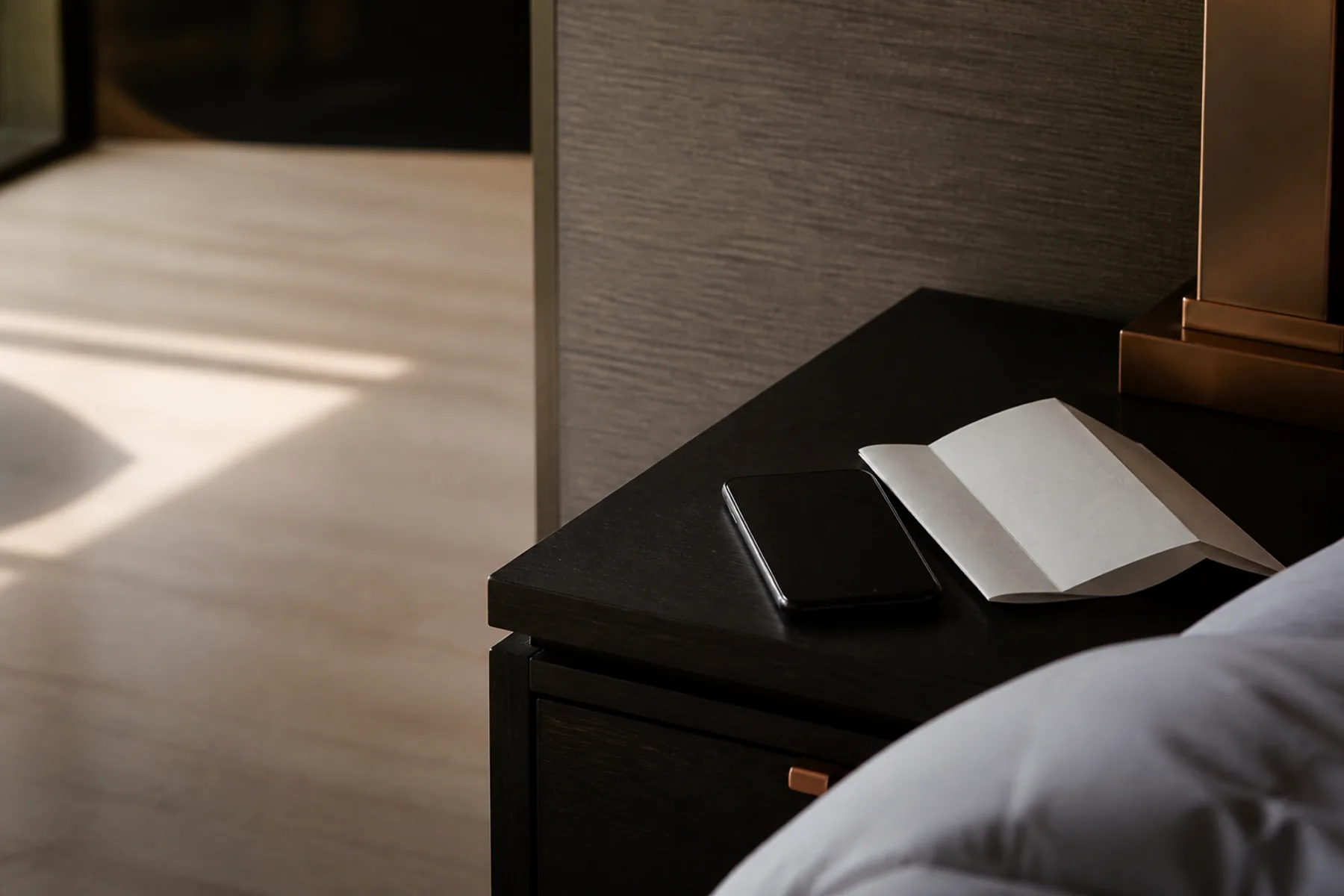 An unopened booking confirmation and a room key on an empty hotel reception desk.