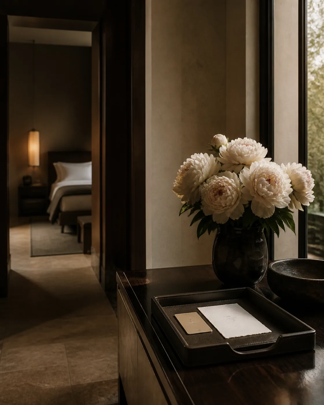 A private residence entrance hall with fresh flowers, post laid out, and the door standing open to a garden.